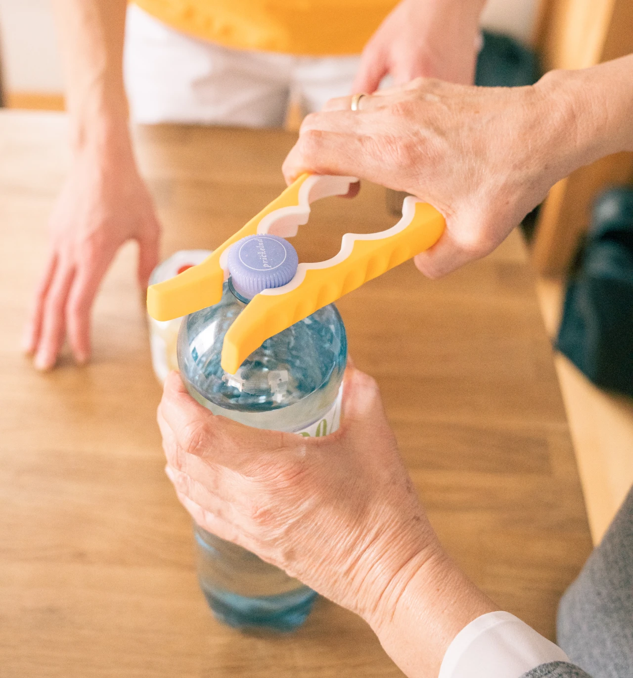 Kristina Wagner unterstützt im Rahmen der Ergotherapie in Graz dabei, mit einer Alltagshilfe eine Flasche leichter zu öffnen und den Alltag selbstständig zu meistern