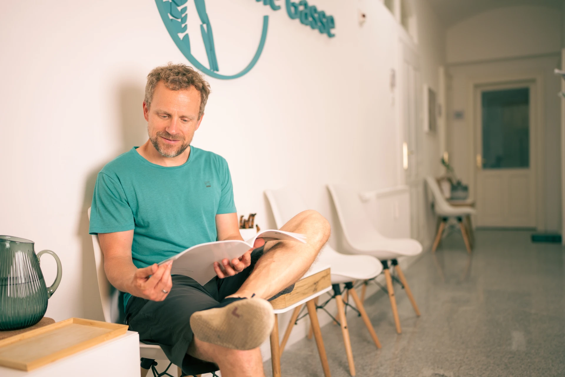 Praxis in der Grünen Gasse für Ergotherapie in Graz mit sitzendem Patienten im hellen Wartebereich - Kristina Wagner